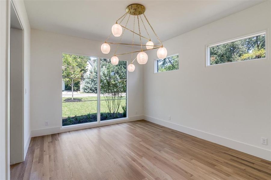 Unfurnished dining area with light wood-style floors and baseboards Unfurnished dining area with light wood-style floors and baseboards