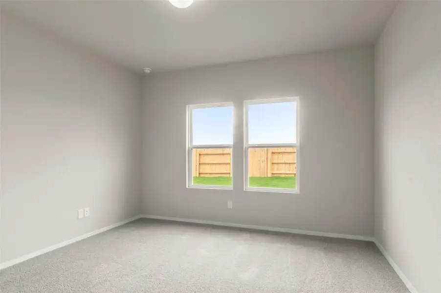 Spare room with light carpet and baseboards
