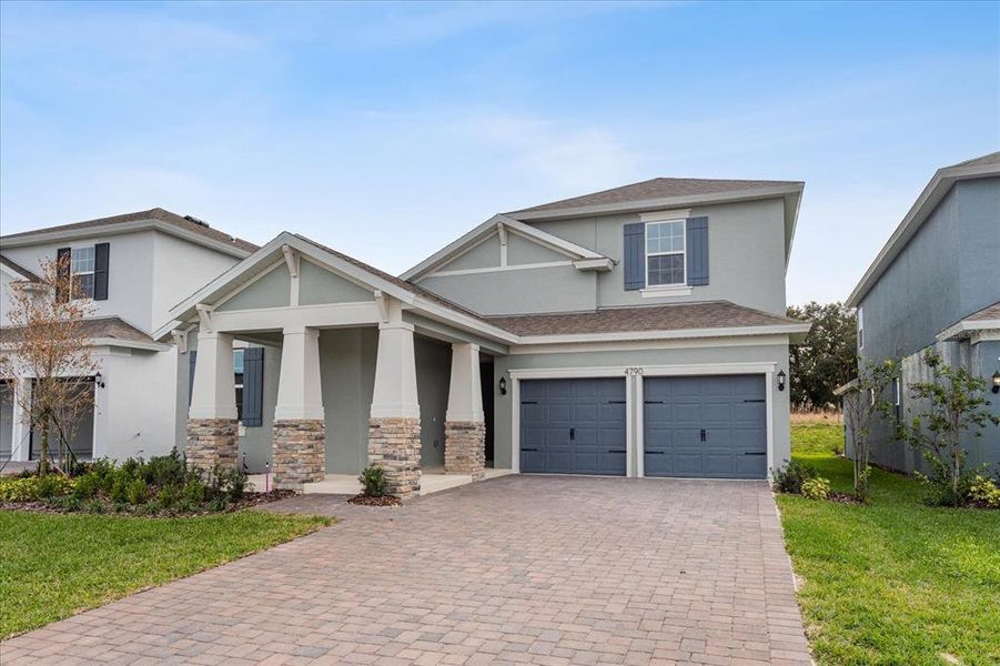Front exterior of a new home in Serenade at Ovation, Winter Garden, FL, highlighting curb appeal (Image 1). Front exterior of a new home in Serenade at Ovation, Winter Garden, FL, highlighting curb appeal (Image 1).