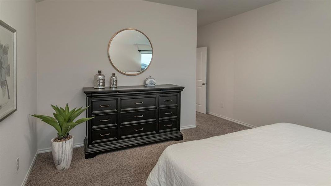 Bedroom with dark carpet and baseboards