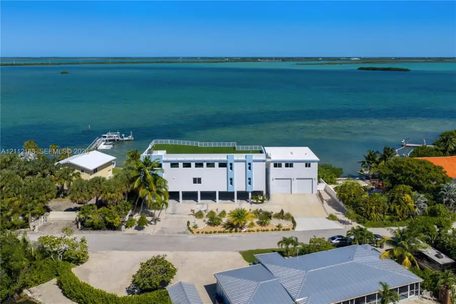 Waterfront property featuring a rooftop terrace, multi-level construction, attached two-car garage, and private dock Waterfront property featuring a rooftop terrace, multi-level construction, attached two-car garage, and private dock
