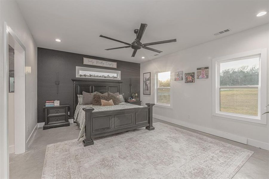 Bedroom with ceiling fan, recessed lighting, and concrete flooring