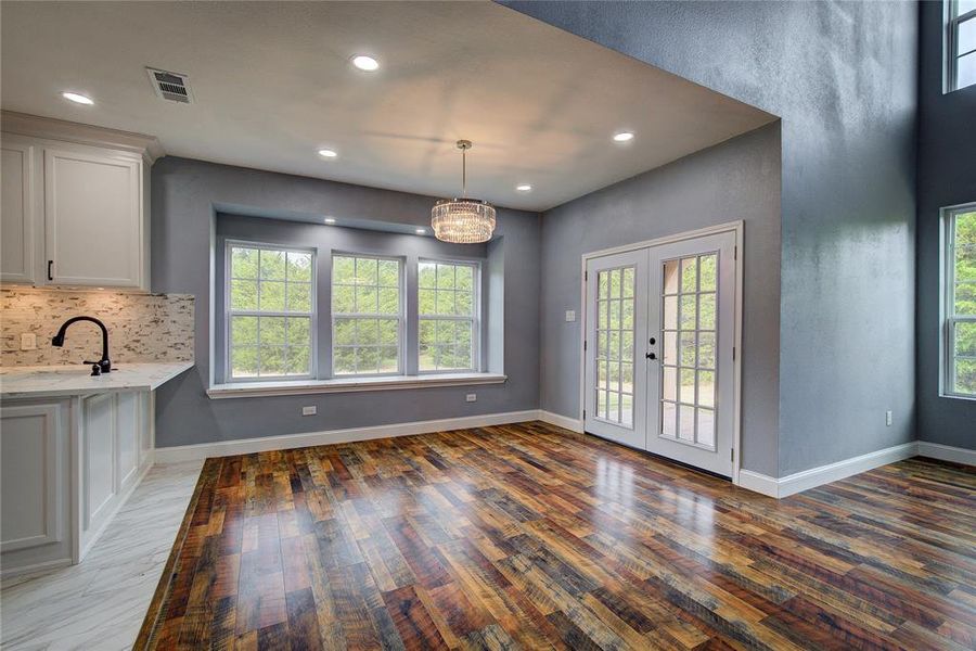 Unfurnished dining area featuring a wealth of natural light, french doors, and dark wood-type flooring