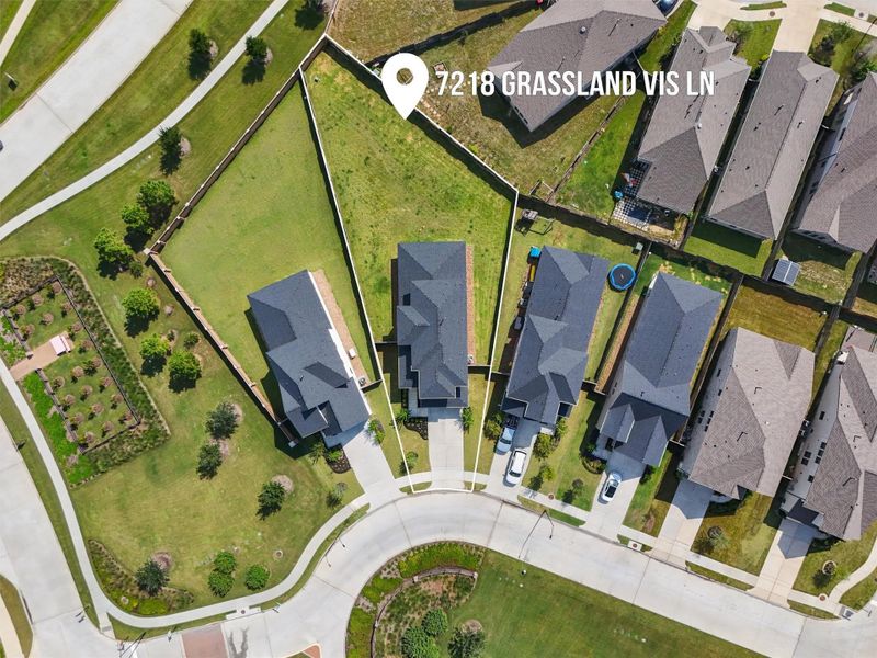 This top-down aerial view clearly outlines the property at 7218 Grassland Vista Lane, allowing potential buyers to see its impressive size and prime location. The large lot and spacious side yards are clearly visible, highlighting the home's unique selling point.