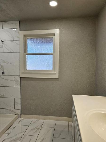 Bathroom featuring vanity and tiled shower Bathroom featuring vanity and tiled shower