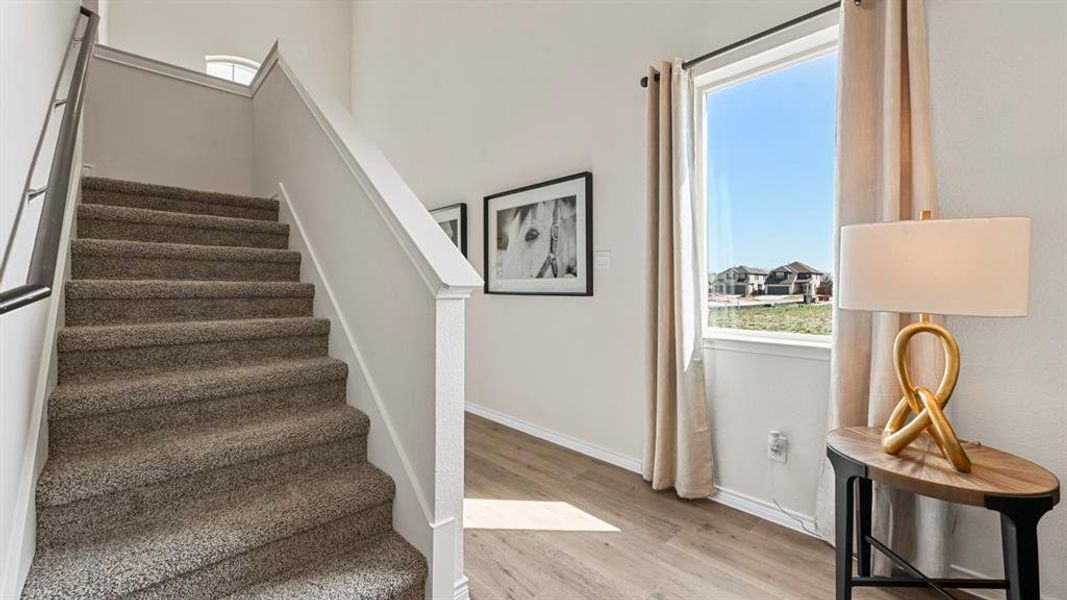 Staircase with plenty of natural light and wood finished floors Staircase with plenty of natural light and wood finished floors