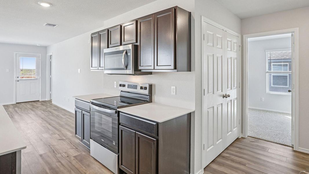 A well-lit kitchen with sleek wooden cabinetry and modern stainless steel appliances. A well-lit kitchen with sleek wooden cabinetry and modern stainless steel appliances.