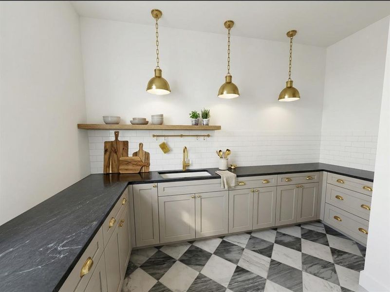 Kitchen featuring dark countertops with light veining, white subway tile backsplash, and light-toned cabinetry with brass hardware