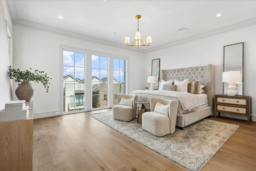 The primary bedroom showcases the wide-plank engineered European French Oak Old Vineyard flooring. Perth chandelier, crown moulding, and large windows make this a welcome oasis.