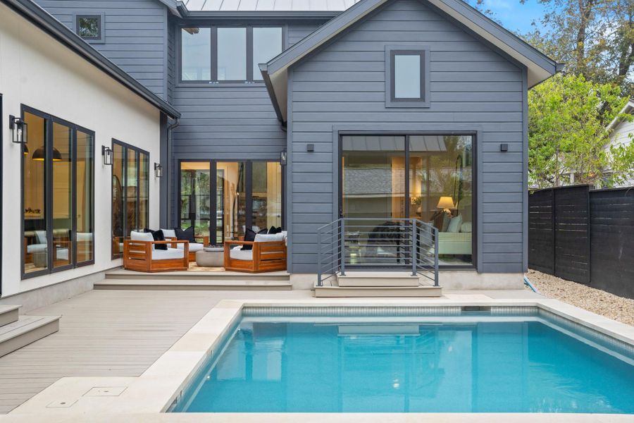 Rear view of property featuring an outdoor pool, outdoor lounge area, a standing seam roof, and a patio