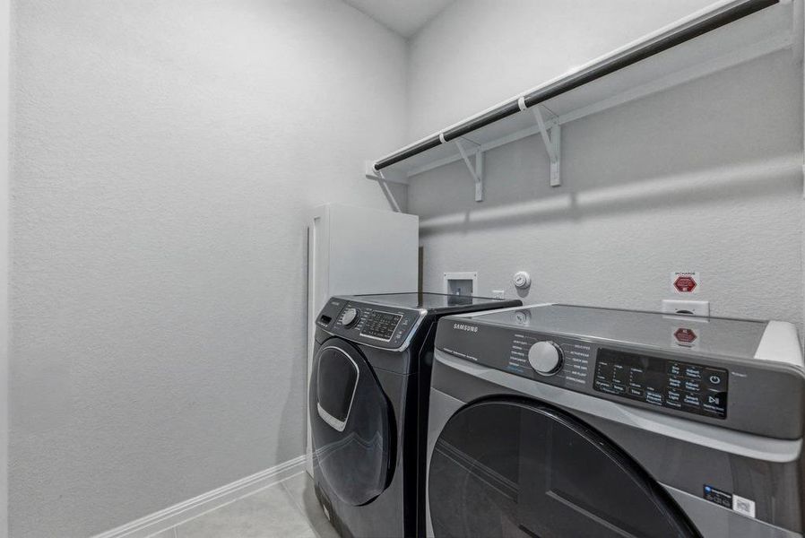 Washroom with washer and dryer and a textured wall