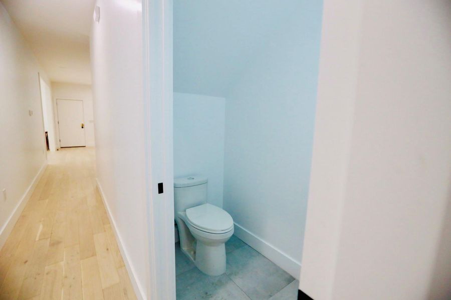 Bathroom featuring toilet and light wood finished floors
