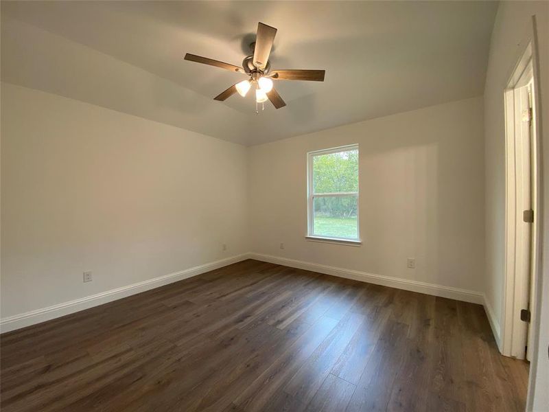Bedroom featuring dark wood finished floors and a ceiling fan Bedroom featuring dark wood finished floors and a ceiling fan