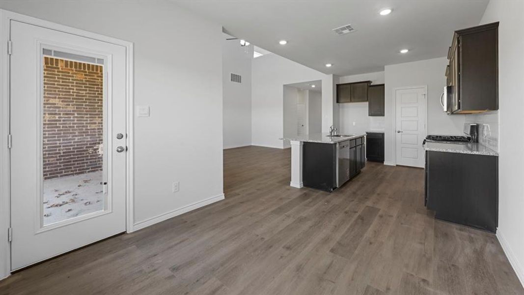 Kitchen featuring dark cabinetry, stainless steel appliances, and granite countertops Kitchen featuring dark cabinetry, stainless steel appliances, and granite countertops