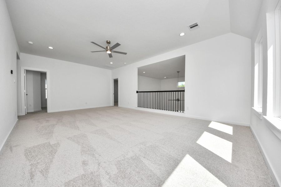 Ascend to relaxation in this fantastic game room! Ideal for both casual gatherings and adult gaming, it boasts plush carpet, lofty ceilings, custom paint, and ample windows for abundant natural light. Sample photo of completed home with similar floor plan. Actual colors and selections may vary.