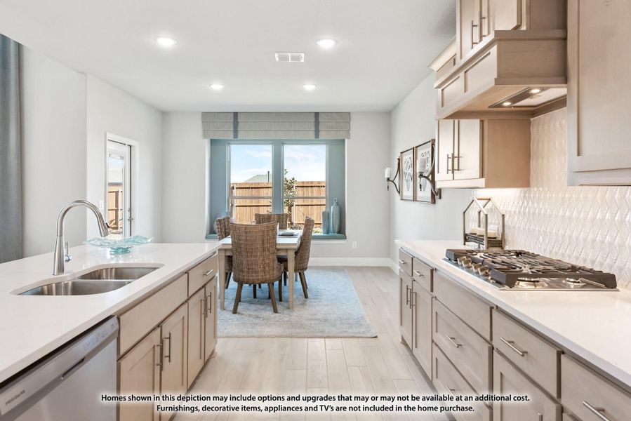 Kitchen with light wood cabinets, white countertops, gas cooktop, and dining area with window view.