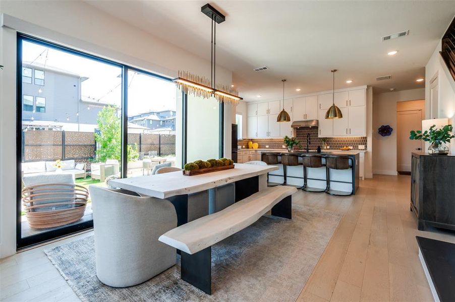 Open concept floor plan.  View from dining area to kitchen.  Gorgeous view of backyard through wall of sliding glass doors.