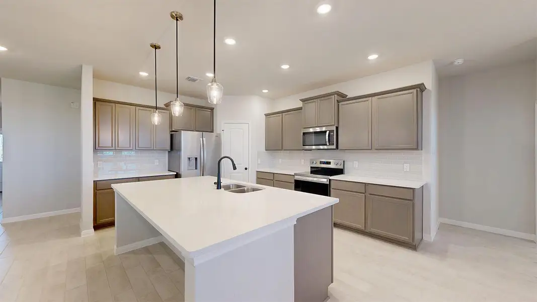 Kitchen featuring stainless steel appliances, decorative light fixtures, tasteful backsplash, a center island with sink, and light wood-style floors