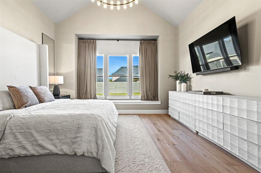 Bedroom with lofted ceiling, light wood-type flooring, and a chandelier Bedroom with lofted ceiling, light wood-type flooring, and a chandelier