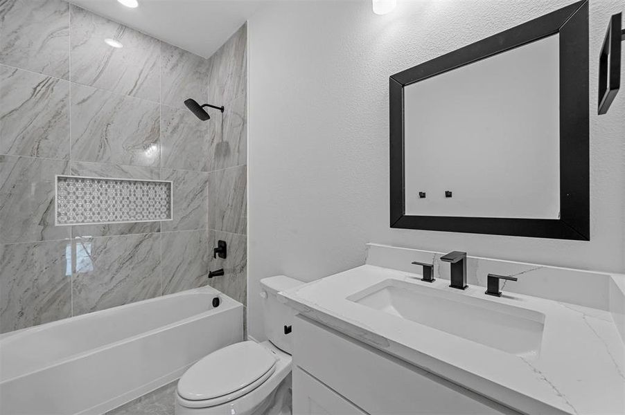 Full bathroom with tiled shower / bath, toilet, and vanity