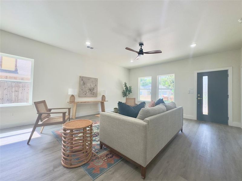 Living room with wood-type flooring and ceiling fan