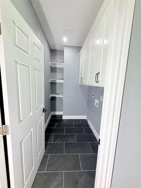 Utility room featuring dark rectangular floor tiles and light gray walls