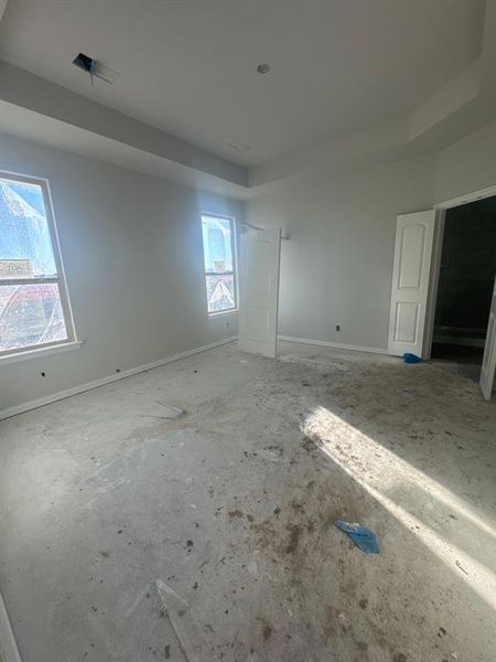Unfurnished bedroom with baseboards and a raised ceiling Unfurnished bedroom with baseboards and a raised ceiling