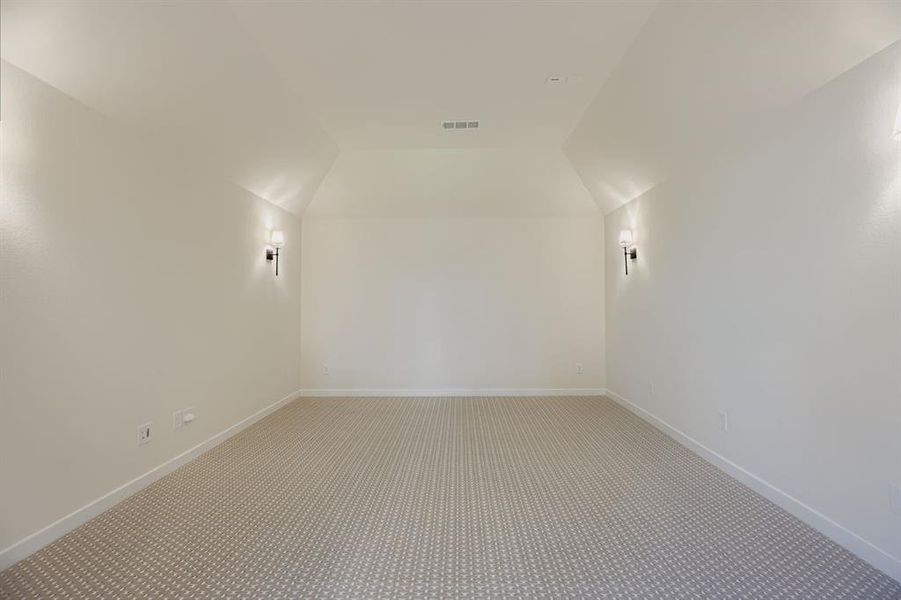 Bonus room with carpet flooring and lofted ceiling