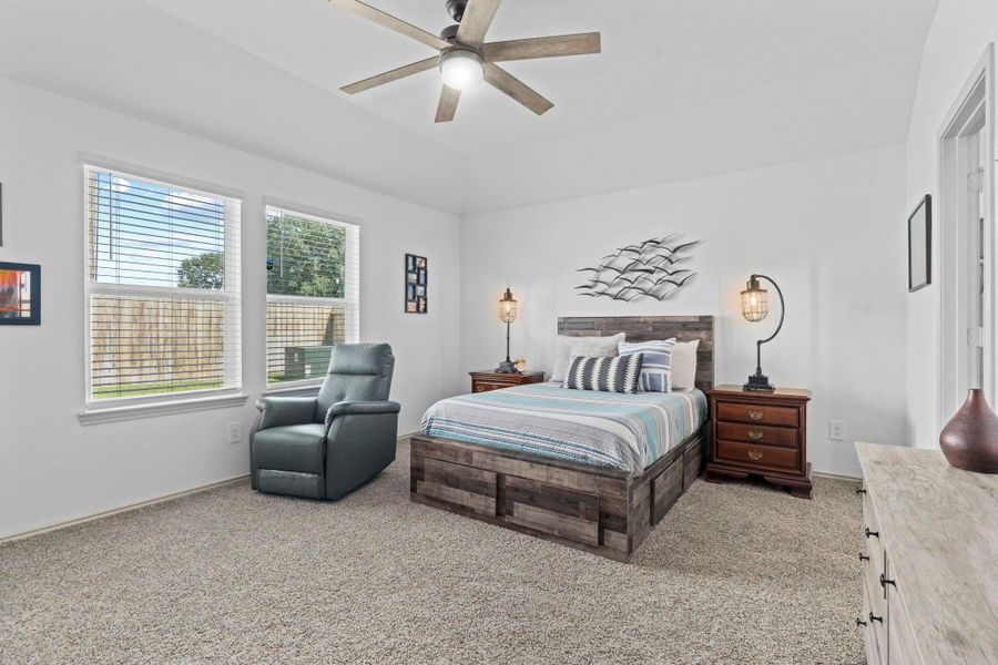 Spacious primary suite tucked away for privacy, featuring large windows with private backyard views, no one behind you! Sink your toes into the soft plush carpet, and a stylish ceiling fan — the perfect retreat after a long day. Spacious primary suite tucked away for privacy, featuring large windows with private backyard views, no one behind you! Sink your toes into the soft plush carpet, and a stylish ceiling fan — the perfect retreat after a long day.