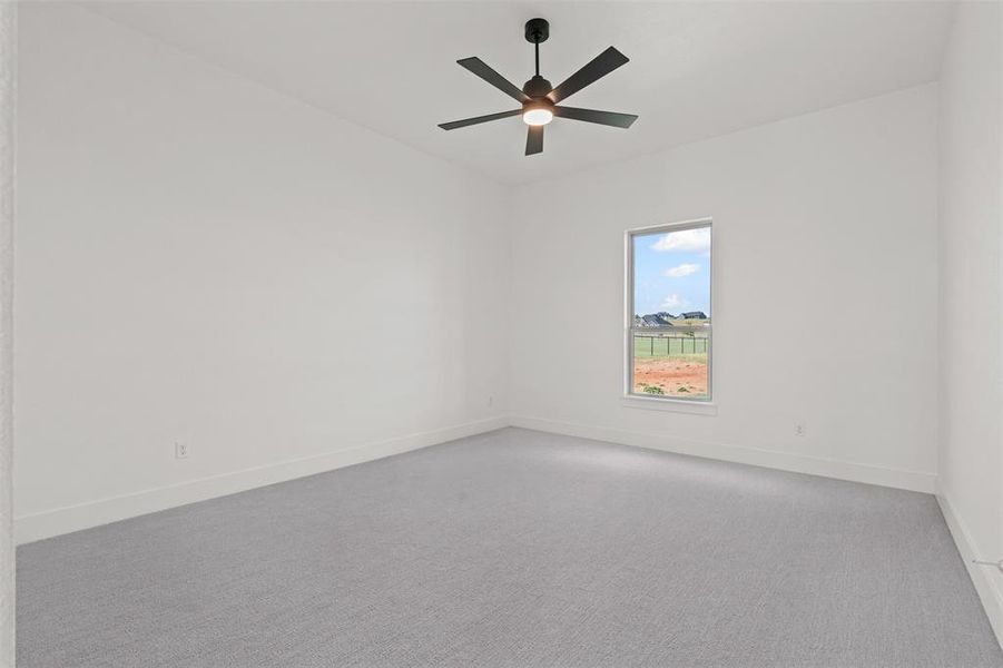 Empty room with carpet floors and ceiling fan