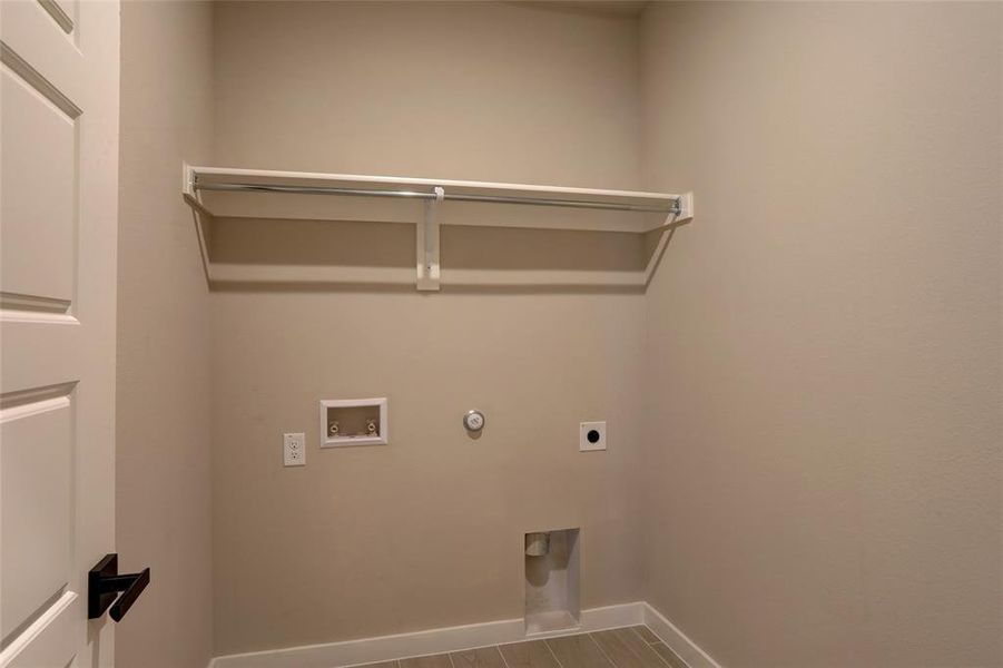 Laundry room featuring hardwood / wood-style flooring, washer hookup, hookup for a gas dryer, and electric dryer hookup