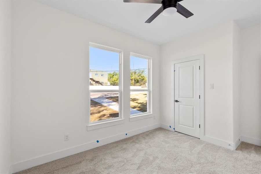 Spare room featuring light carpet and ceiling fan