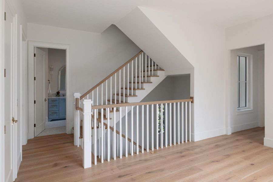 Stair detail includes stained white oak hand rails, with white spindles and newel posts.