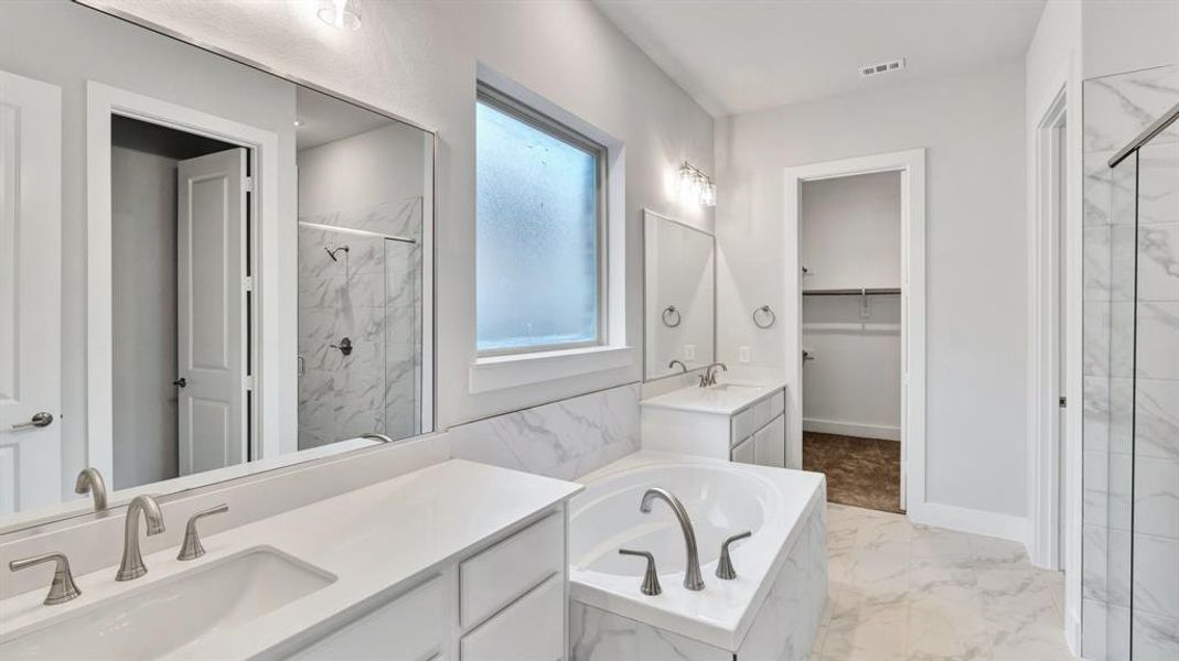 Bathroom featuring vanity and shower with separate bathtub