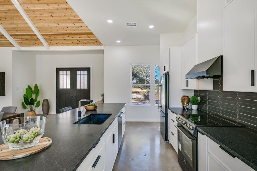 Kitchen with concrete floors, black / electric stove, recessed lighting, range hood, and wood ceiling