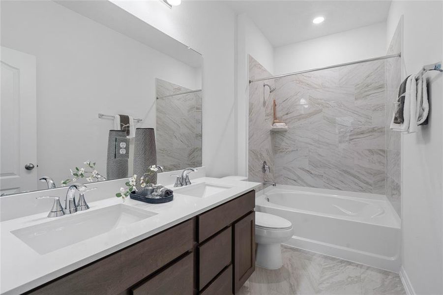 This primary bathroom is definitely move-in ready! Featuring an oversized tub/shower combo with tile surround, stained cabinets with light countertops, high ceilings, custom paint, sleek and modern finishes.