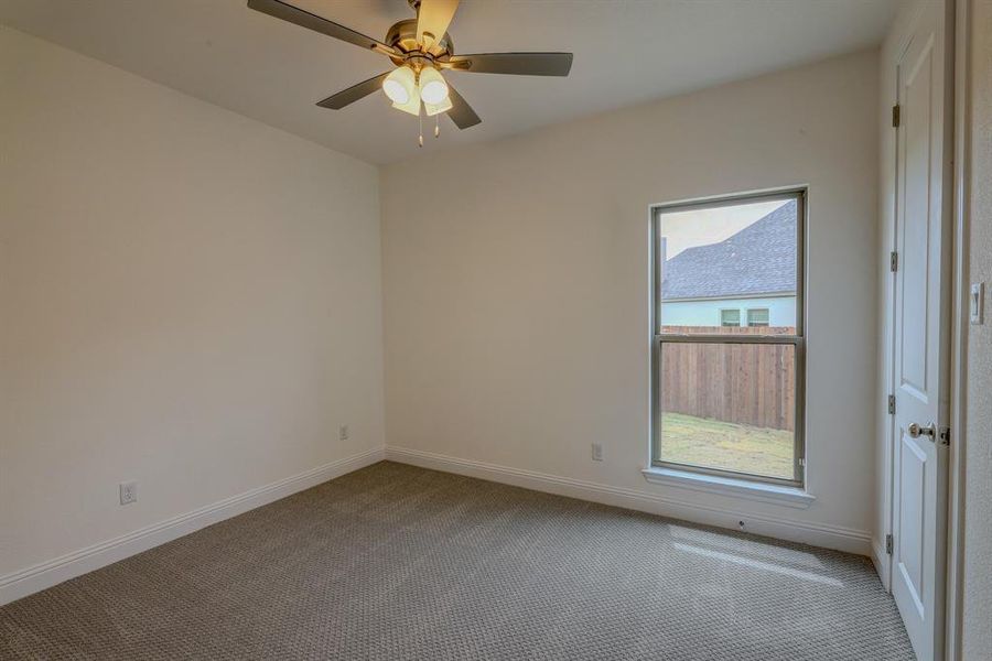 Unfurnished room with carpet flooring, baseboards, and ceiling fan