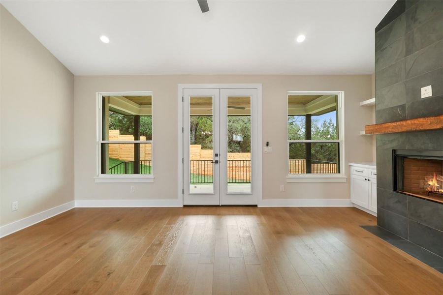 Entryway featuring recessed lighting, a tile fireplace, light wood-style floors, baseboards, and french doors Entryway featuring recessed lighting, a tile fireplace, light wood-style floors, baseboards, and french doors
