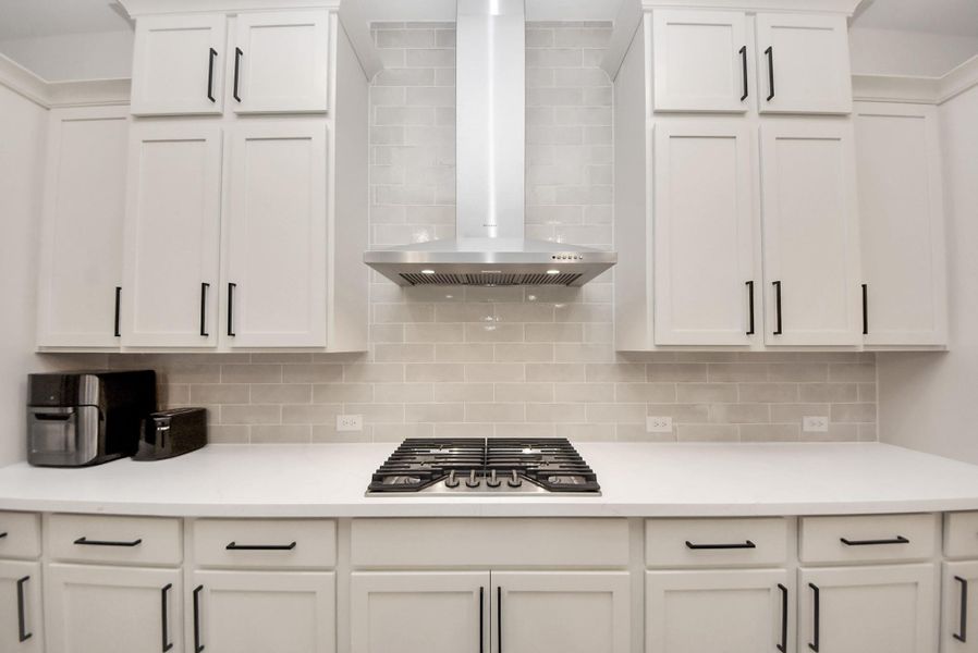 Modern kitchen with a gas cooktop, subway tile backsplash, and generous prep space.
