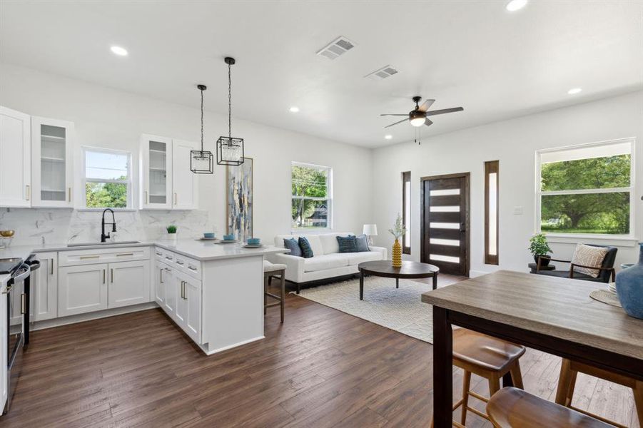 Kitchen featuring open floor plan, a peninsula, a sink, and pendant lights Kitchen featuring open floor plan, a peninsula, a sink, and pendant lights
