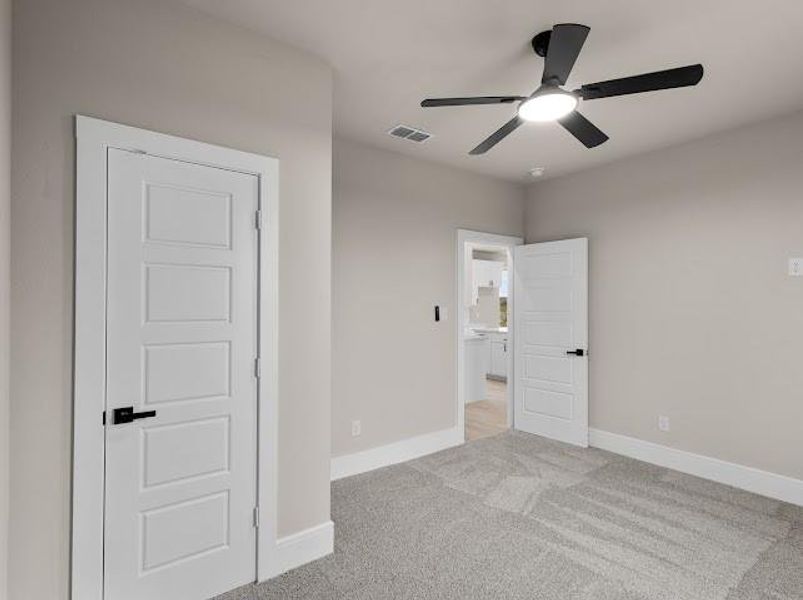 Unfurnished bedroom featuring light carpet and a ceiling fan