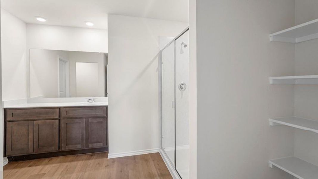 Bathroom featuring a dark wood-finish vanity with a single sink and a large mirror