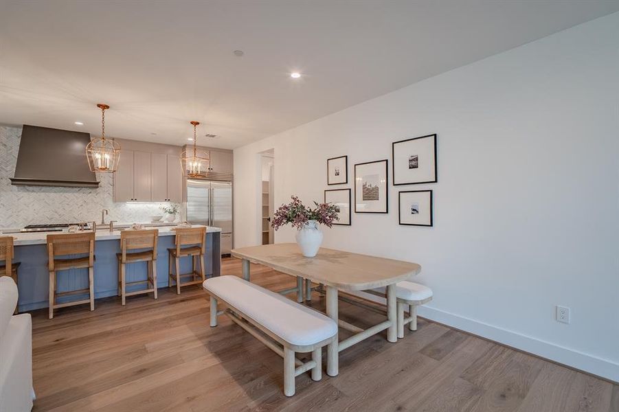 Dining area featuring light wood-style floors, recessed lighting, and a chandelier Dining area featuring light wood-style floors, recessed lighting, and a chandelier