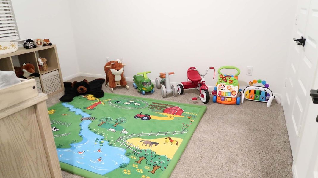 This photo features a cozy children's playroom with carpeted flooring. Bright and welcoming, it's ideal for family living. This photo features a cozy children's playroom with carpeted flooring. Bright and welcoming, it's ideal for family living.
