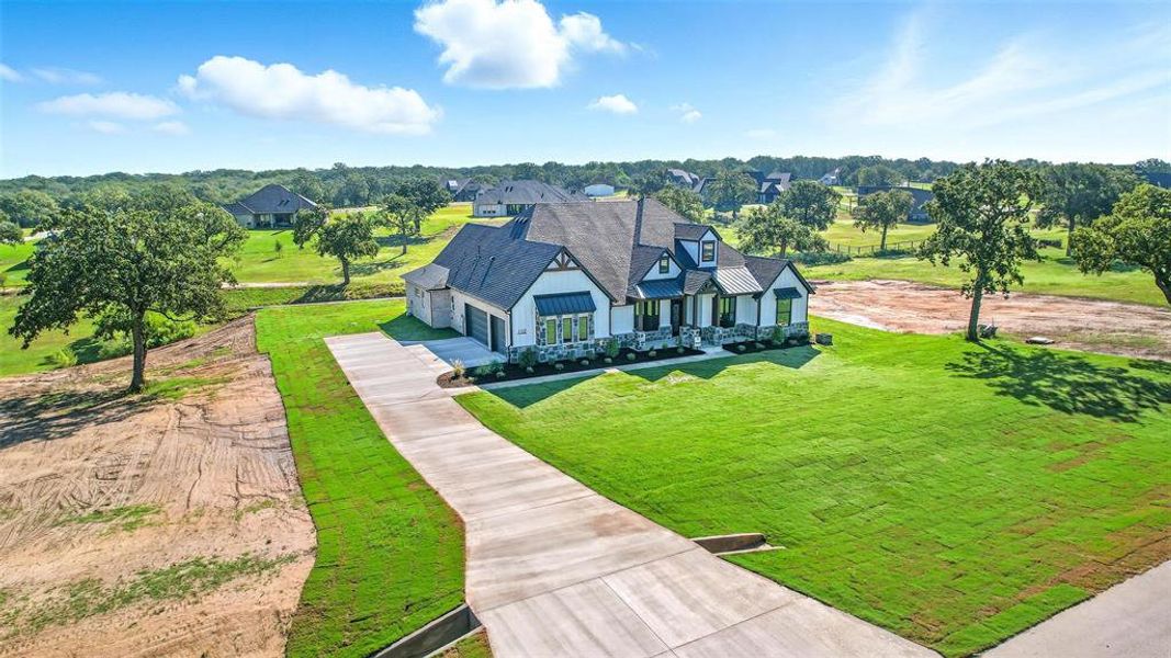View of front of home featuring driveway, a front lawn, a metal roof, covered porch, and a standing seam roof