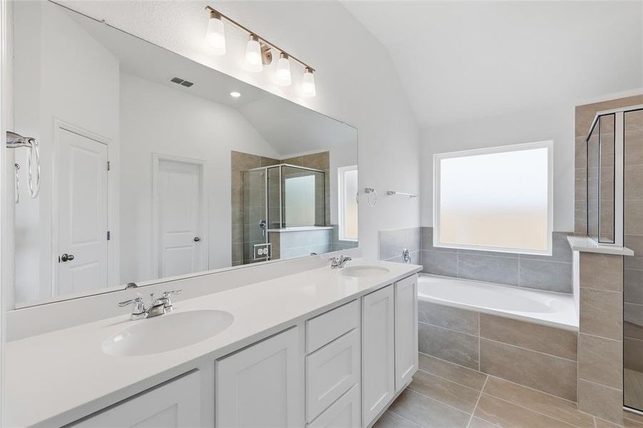 Bathroom featuring a dual vanity with white cabinetry and integrated sinks
