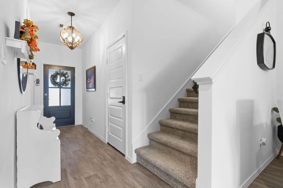 Inviting foyer next to the staircase, setting a warm and elegant tone as you enter the home. Inviting foyer next to the staircase, setting a warm and elegant tone as you enter the home.