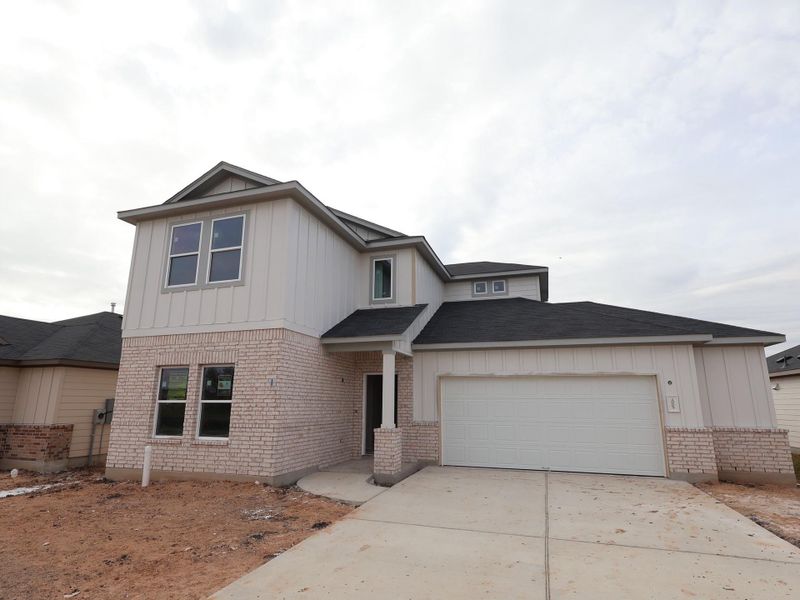 Front exterior of a new home in Carillon, Manor, TX, highlighting curb appeal (Image 1).