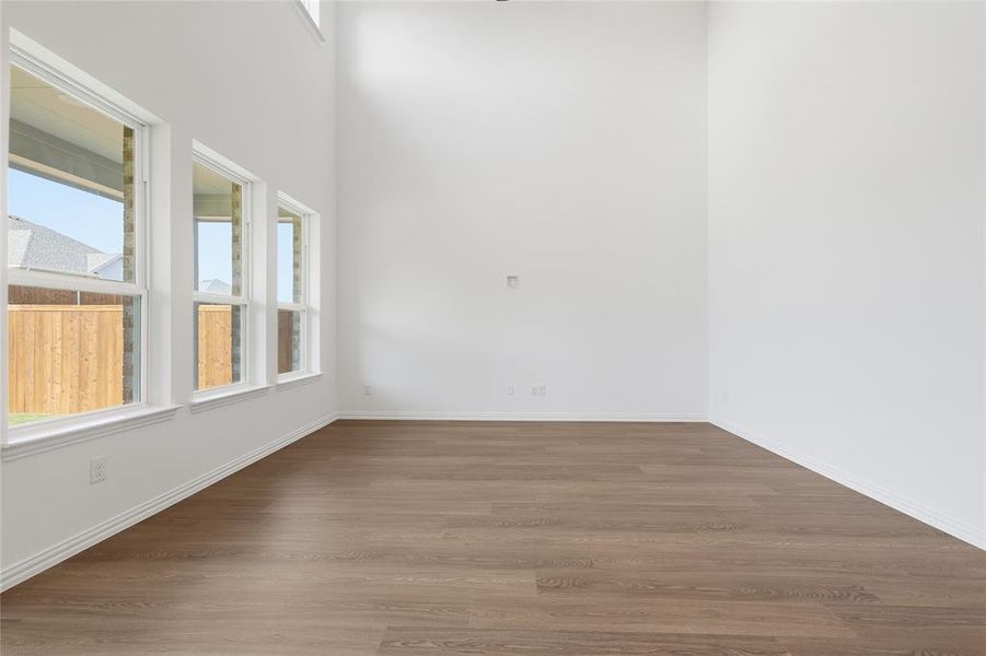 Empty room featuring wood finished floors and a high ceiling