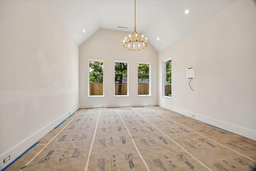 The spacious owner’s retreat is located on the first floor and features a vaulted ceiling, chandelier, seating area, and generously sized windows overlooking the backyard.